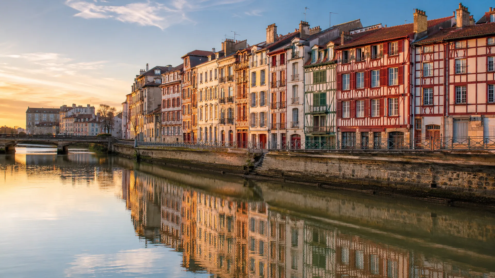 Conciergerie à Bayonne : les façades à colombages du Petit Bayonne le long de la Nive au lever du soleil